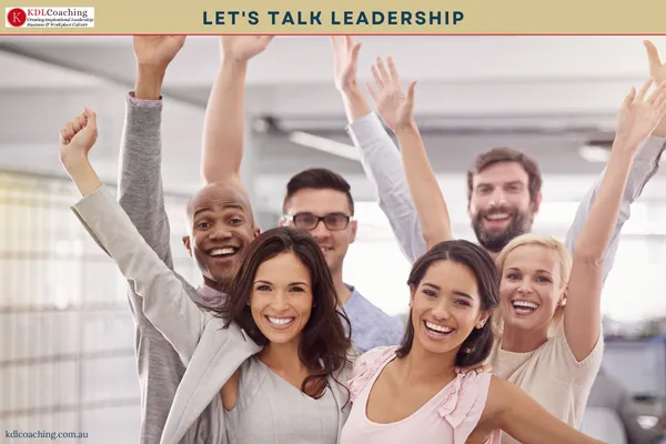 Team of colleagues cheering with their arms raised