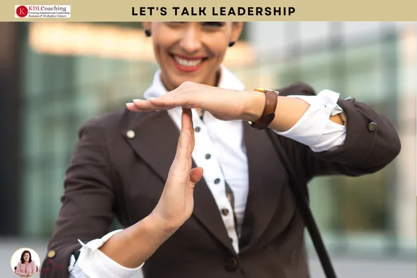 Smiling businesswoman making a time-out sign with her hands