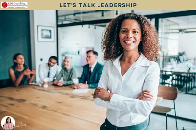 Confident woman with her arms folded in front of her team at a meeting table