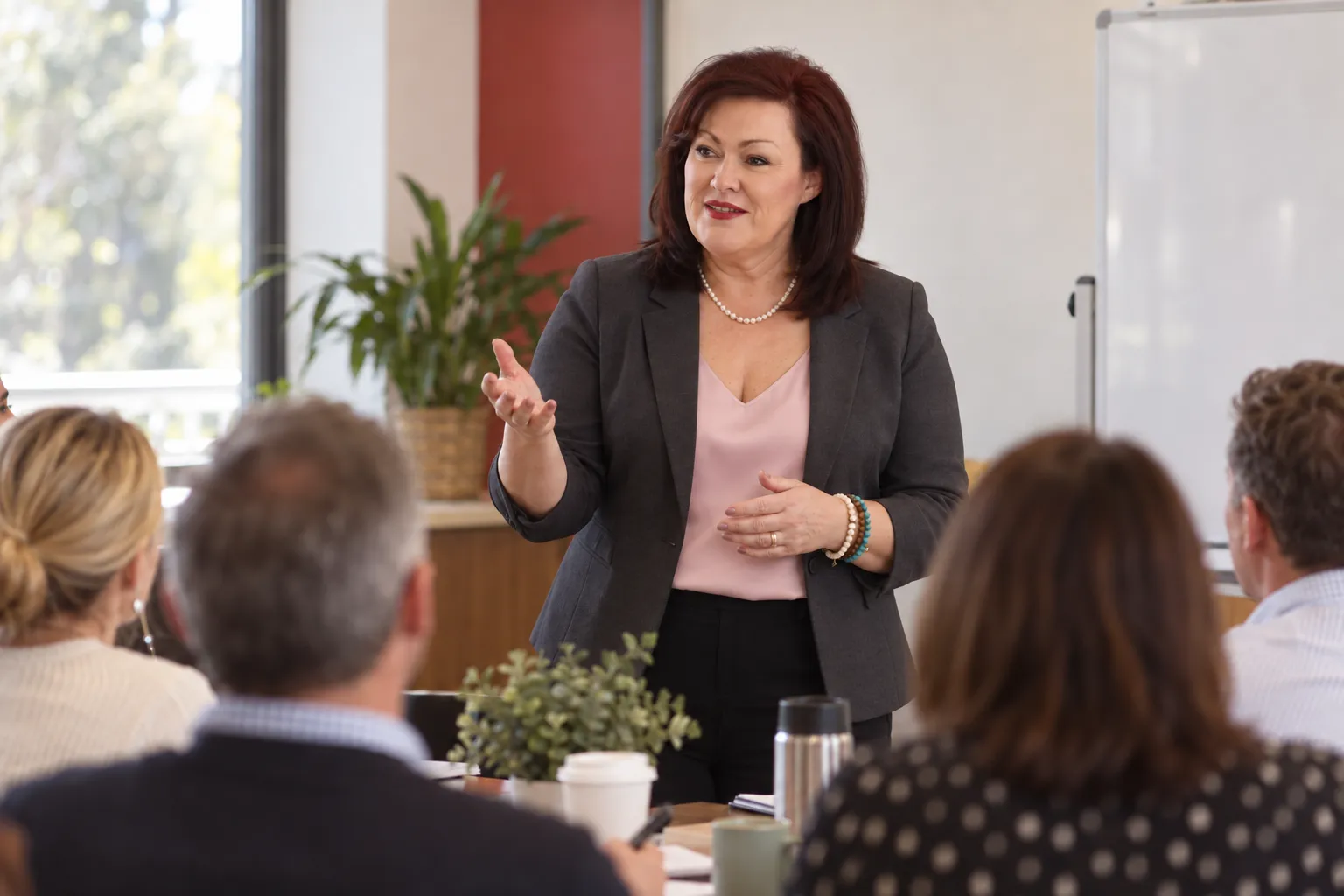 Karen Davey talking with a group of leaders around a table